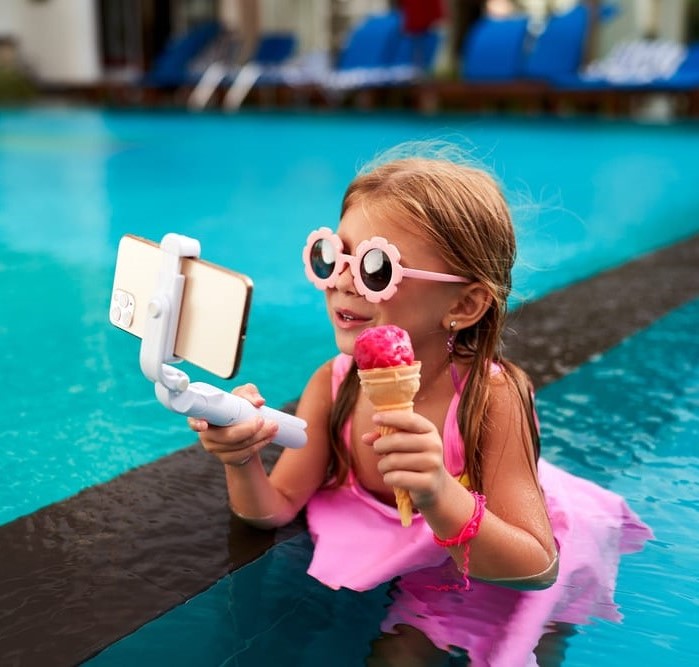 A young social media influencer eating ice cream by the pool